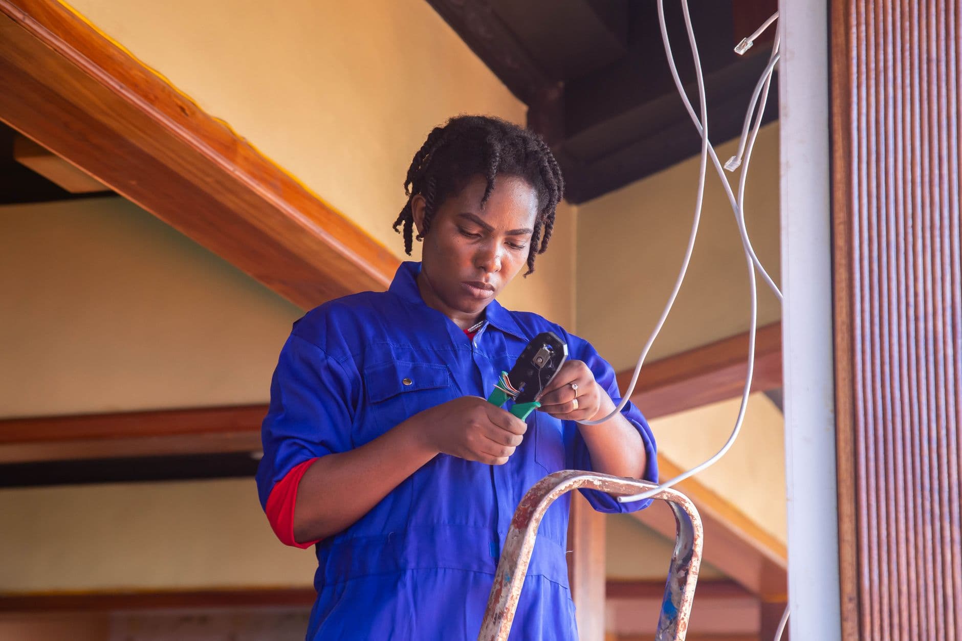 A technician on a ladder working on wiring